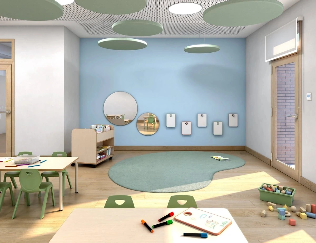 Mintgrüne Kindergartenstühle aus Kunststoff neben dem Spielbereich eines Gruppenraums