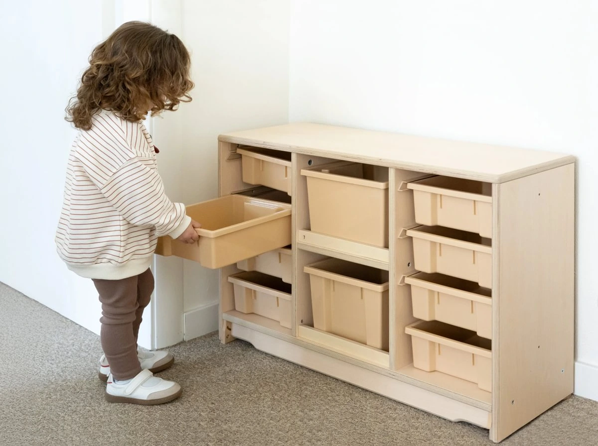 Kind entnimmt eine Box aus dem Aufbewahrungswagen PINE